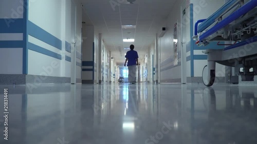 Female Doctor Walking through the Long Hallway in Hospital