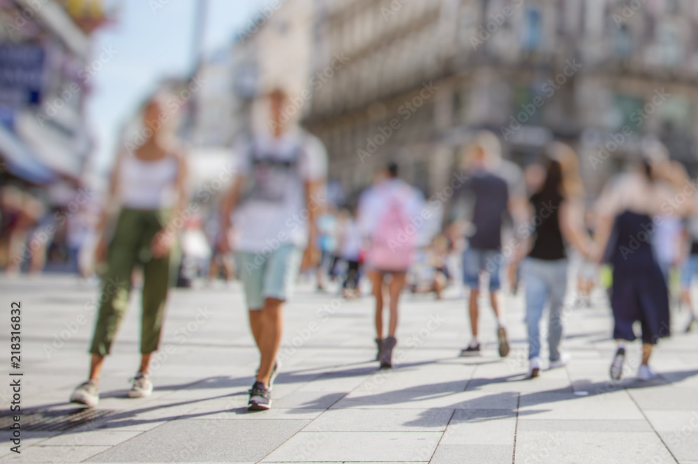 Fototapeta premium Tłum anonimowych ludzi spacerujący po ruchliwej ulicy miasta