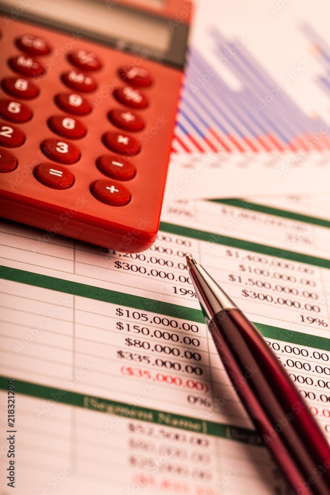Pen and Calculator on Business Graphs and Charts Pen and Calculator on Business Graphs and Charts