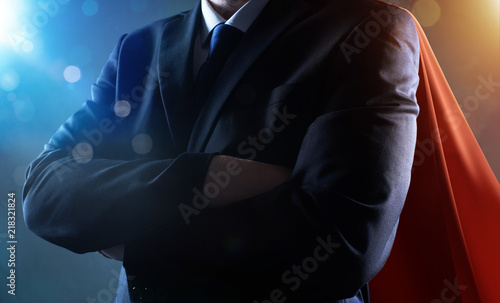Closeup Businessman in suit and cape hero with crossed arms . bokeh and light flare effect apply .