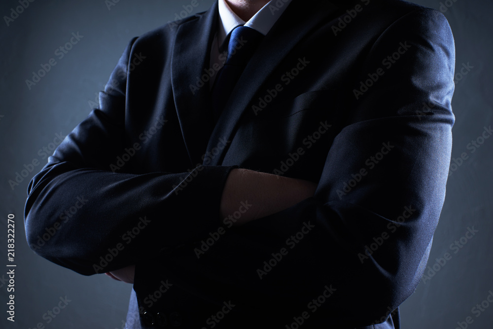 Closeup business man with crossed arms on black background Closeup business man with crossed arms on black background
