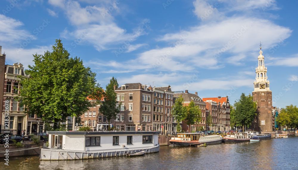 Historical tower Montelbaanstoren and houseboats in Amsterdam, Netherlands