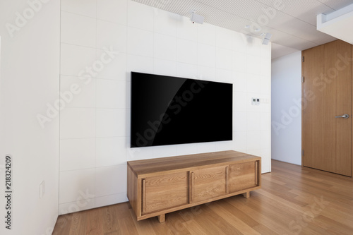 television with wood shelf in a white interior.