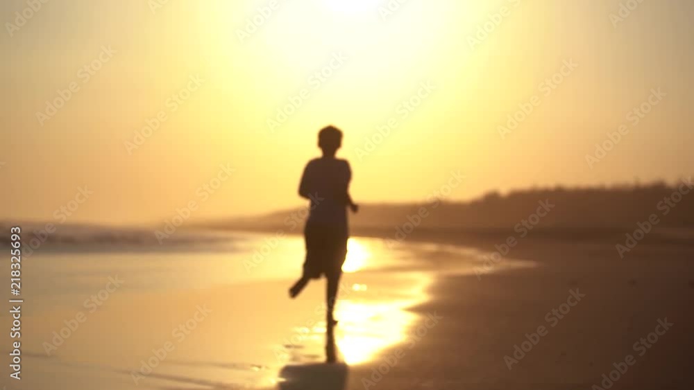 Silhouette of preteen boy running on the beach at sunset time. Shot in 4k resolution Silhouette of preteen boy running on the beach at sunset time. Shot in 4k resolution
