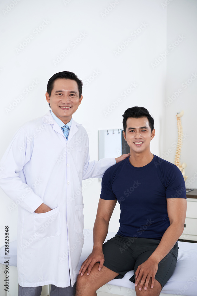 Obraz premium Happy Vietnamese chiropractor and his smiling young patient