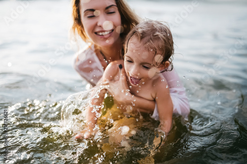 happy mother holding daughter in river © LIGHTFIELD STUDIOS