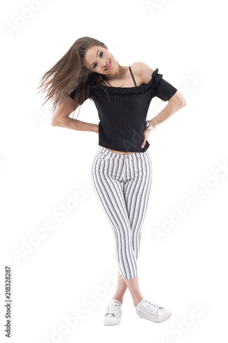 Young stylish woman in striped pants tossing hair and smiling at camera in trendy clothes. Full body isolated on white background. 