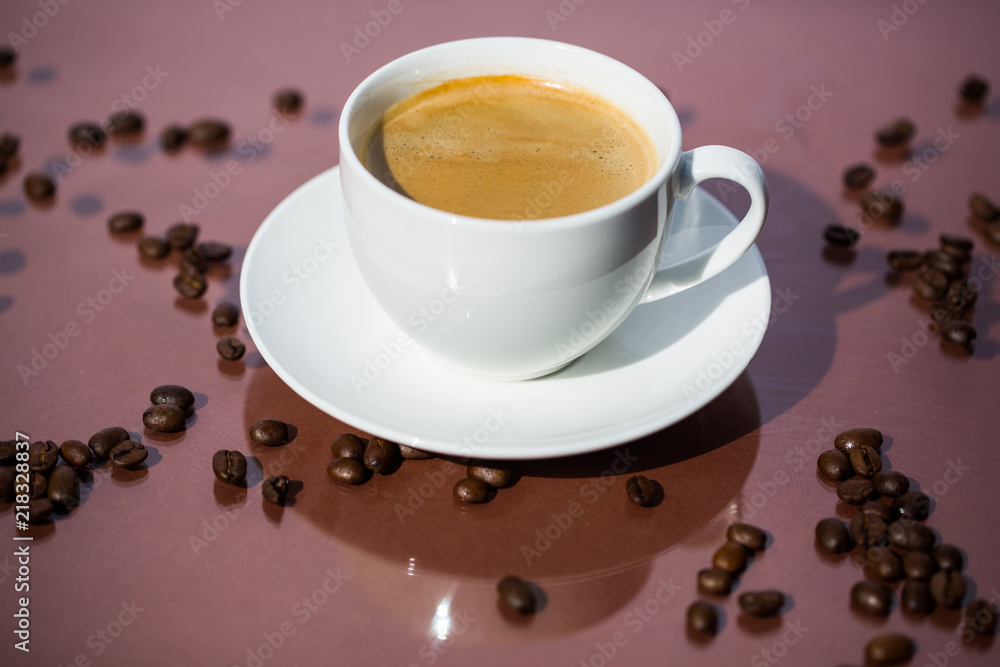 Cup of coffee with coffee beans on brown background Cup of coffee with coffee beans on brown background