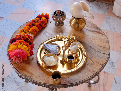 Puja lamp, flower, garland, conch, incense, water, handkerchief on a copper tray - hindu worship.