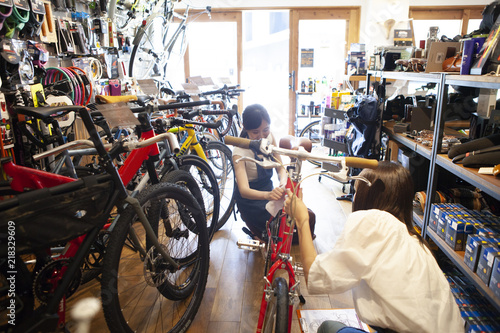 お店で自転車について話している女性とスタッフ