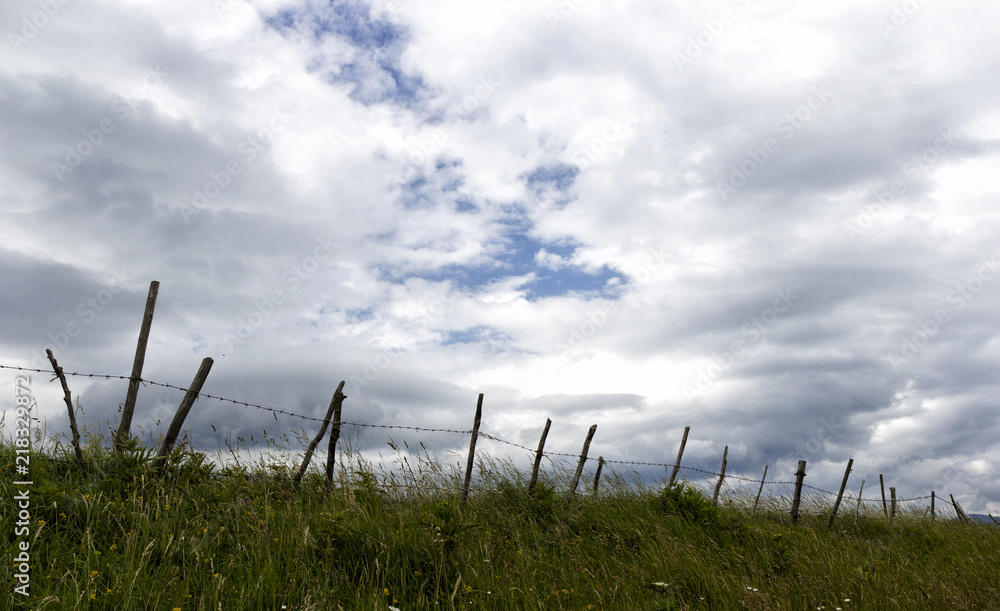 Fototapeta premium fence in the mountains and clouds