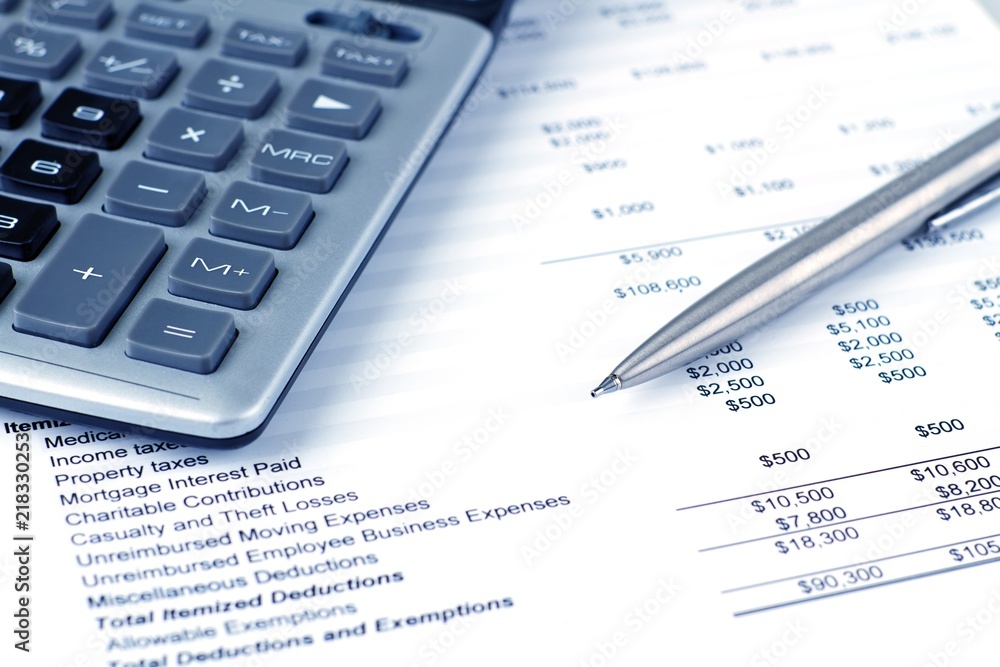 Calculator and pen on top of financial documents Calculator and pen on top of financial documents