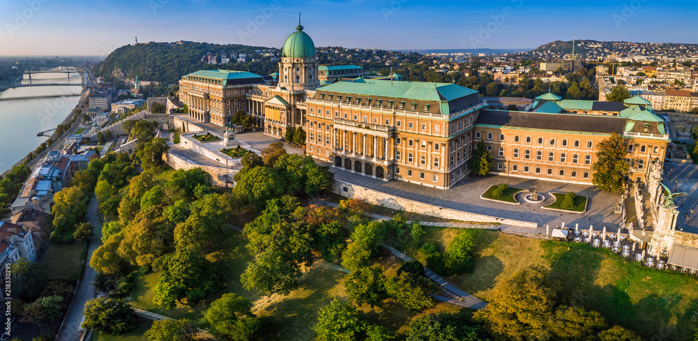 Budapest, Hungary - Aerial panoramic view of the beautiful Buda Castle Royal Palace at sunrise with Gellert Hill and Statue of Liberty at background - obrazy, fototapety, plakaty 