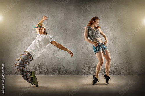 Hip Hop dancer in dynamic action jump on the grunge grey