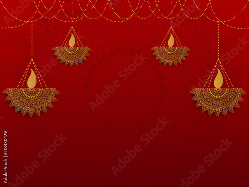 Ornamental floral hanging oil lamps (Diya) on shiny red background with space for your message or text.