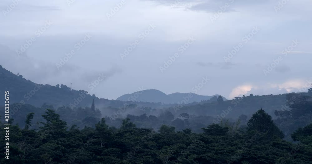 A mountain range in a long shot with clouds and blue sky A mountain range in a long shot with clouds and blue sky