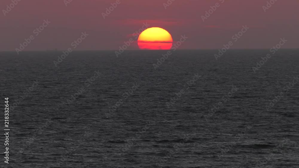 Red sunset. The sun touches the horizon. Calm sea. Small waves. Panning,Closeup, Red sunset. The sun touches the horizon. Calm sea. Small waves. Panning,Closeup,