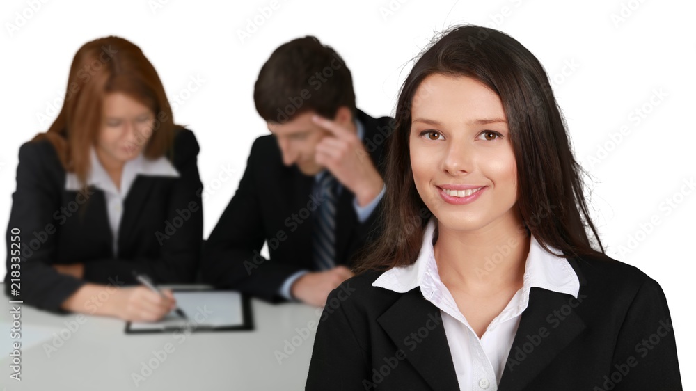 Friendly Businesswoman and Talking Collaborators in Background - Friendly Businesswoman and Talking Collaborators in Background -