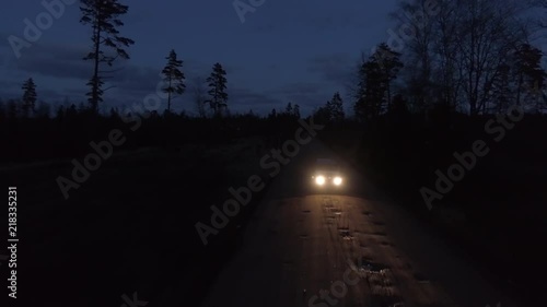 Aerial drone tracking shot of a 4x4 driving in night on a gravel road photo