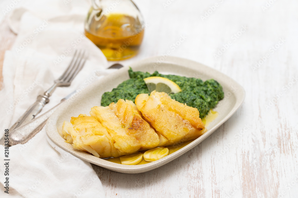 fried cod fish with spinach on dish fried cod fish with spinach on dish
