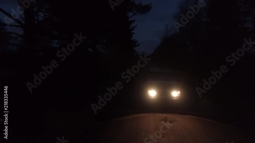 Aerial drone tracking shot of a 4x4 driving in night on a gravel road