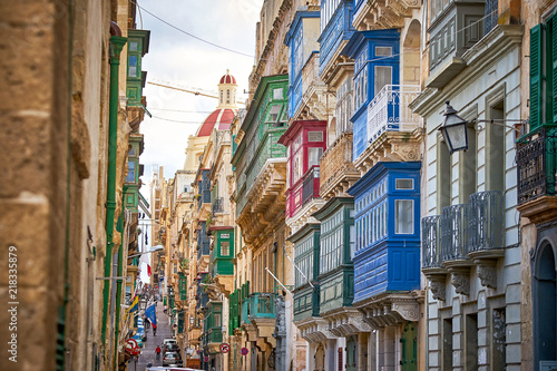 Street in Valetta city with a lot of traditional colorful balconies