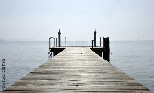 Wooden pier over lake against sky. Bardolino, Italy