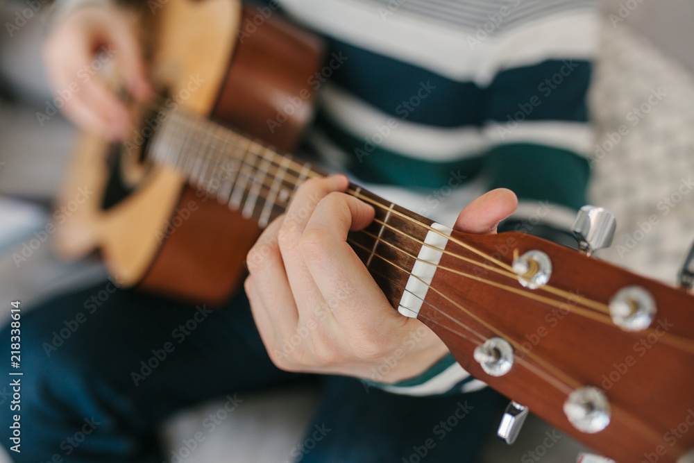 Obraz premium Learning to play the guitar. Music education and extracurricular lessons.