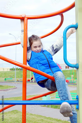 White little girl having fun at the playground outdoor in autumn