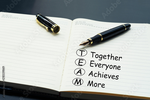 Teamwork concept. luxury pen writing word Teamwork, Together, Everyone, Achieves and More on the daily notebook