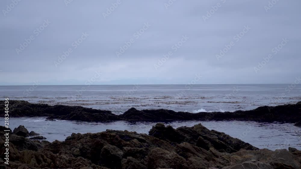 Blue waves splashing into a tide pool at a beach along the California Pacific Coast Blue waves splashing into a tide pool at a beach along the California Pacific Coast