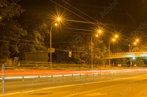 Road at night with traces of car headlights.