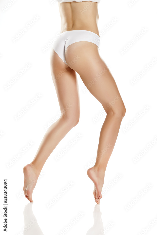 Female bare legs with white panties on white background Female bare legs with white panties on white background