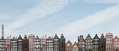 Panorama or panoramic view. Traditional houses in Amsterdam in the Netherlands in a row against the blue sky. photo
