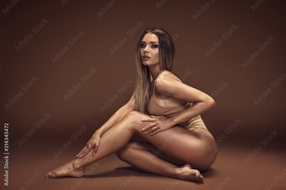 Naklejka premium Sensual brunette woman with ideal tan body.