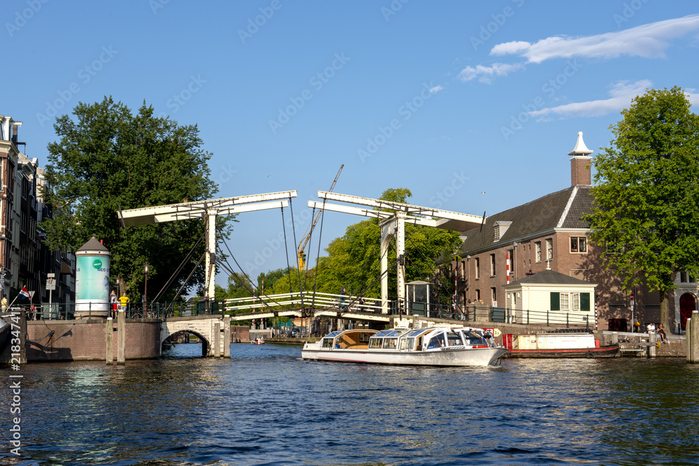 Sightseeing boat passes bridge  in Amsterdam