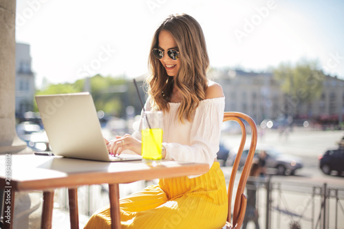 Girl working with laptop sitting at the cafe