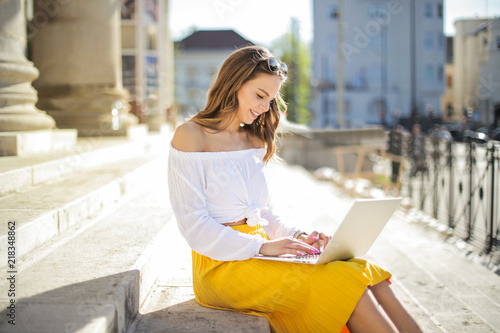 Girl with laptop sitting on the stairs