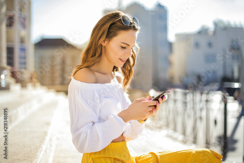 Girl with smart phone sitting on the stairs