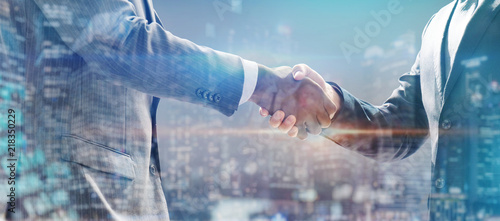 handshake of business people with skyscrapers background and finance and marketing business conclusion photo