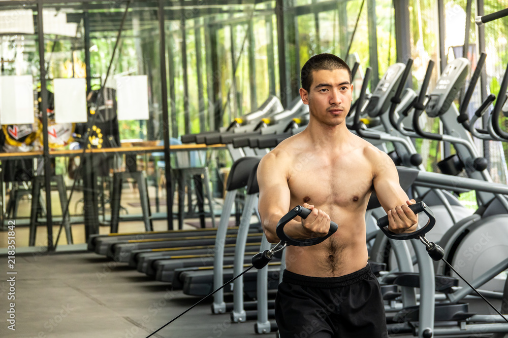 Young sport man exercising in fitness gym Young sport man exercising in fitness gym