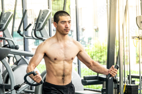 Young sport man exercising in fitness gym