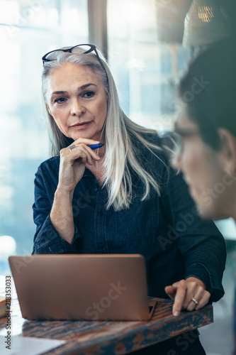 Mature business woman paying attention in meeting photo