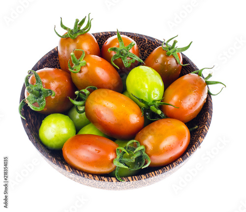 Wooden bowl with mature and immature tomatoes