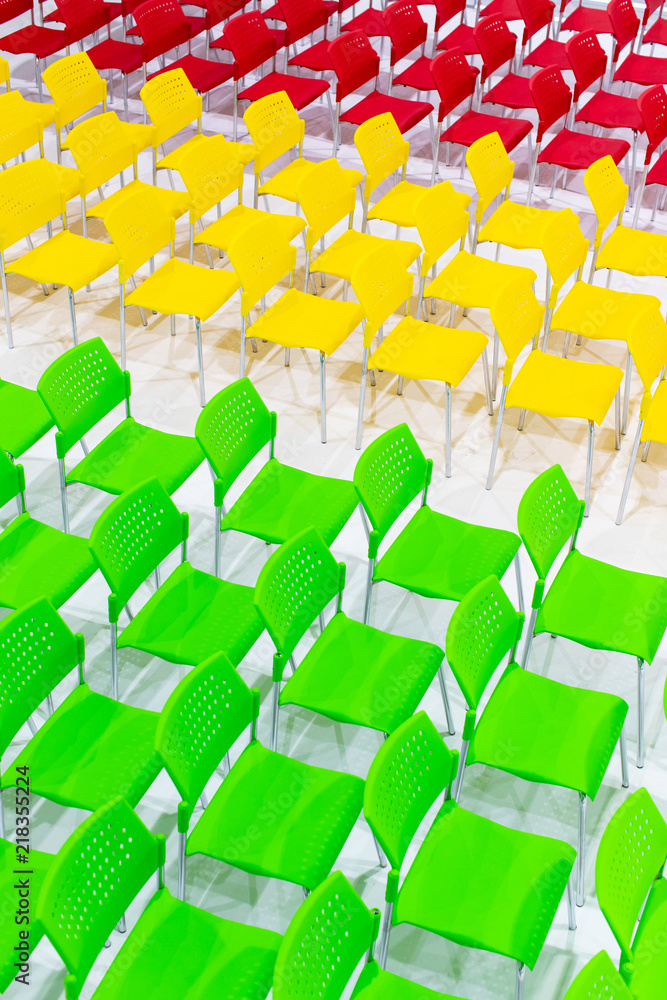 Obraz premium Rows of bright color chairs arranged in meeting room ready to sit. high angle shoot.