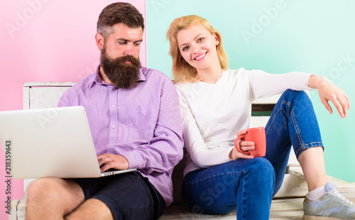Girl enjoy drink while husband freelancer works with laptop. Freelance benefits. Man works as internet technologies expert on freelance. Woman smiling face drink tea or coffee near man working