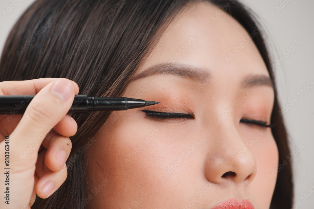 makeup beauty with brush eye liner on pretty woman face makeup beauty with brush eye liner on pretty woman face