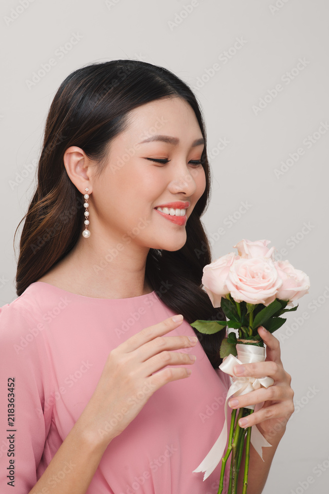 Portrait of a smiling playful cute woman holding flowers isolated on a white background Portrait of a smiling playful cute woman holding flowers isolated on a white background