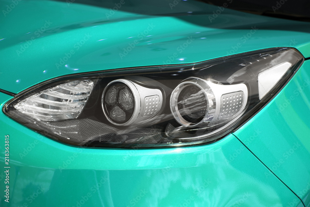 close-up of the front headlight of a new modern colored car. new clean mint car