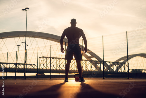 Fitness training outdoors. Handsome man working exercises in early morning with sunrise. Muscular man training outside. Sunny fitness morning.